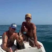 Two men sitting on a boat in the ocean.