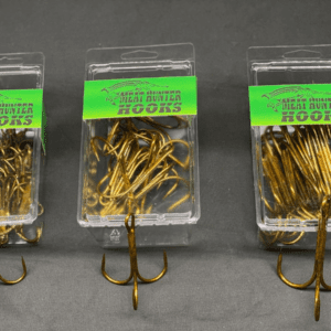 Three plastic containers holding fishing hooks with green labels.