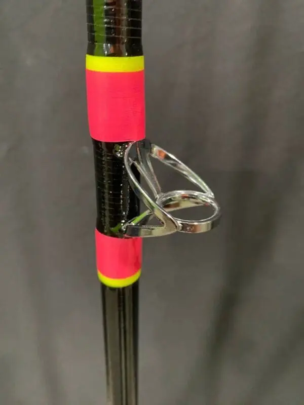 A pink and yellow umbrella with a clear glass holder.