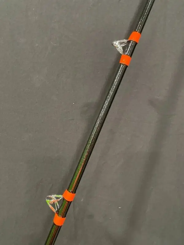 A metal pole with orange plastic clips attached to it.